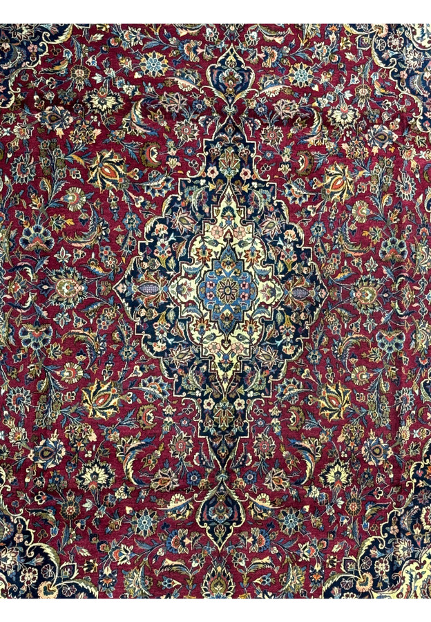 Close-up of the central medallion of a Persian Kashan rug, highlighting the complex designs and vibrant color palette