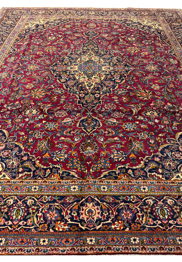 Top-down shot of a Persian Kashan rug, capturing the grandeur and complexity of its traditional design and craftsmanship