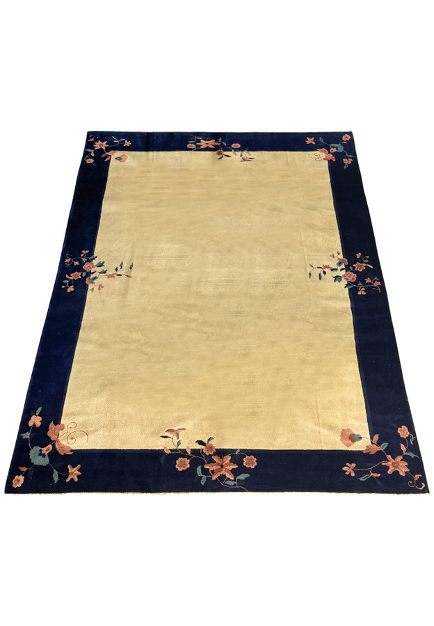 Full view of a large 8'2" x 11'2" Vintage Art Deco Rug laid out, with a detailed navy border and a beige field adorned with floral patterns