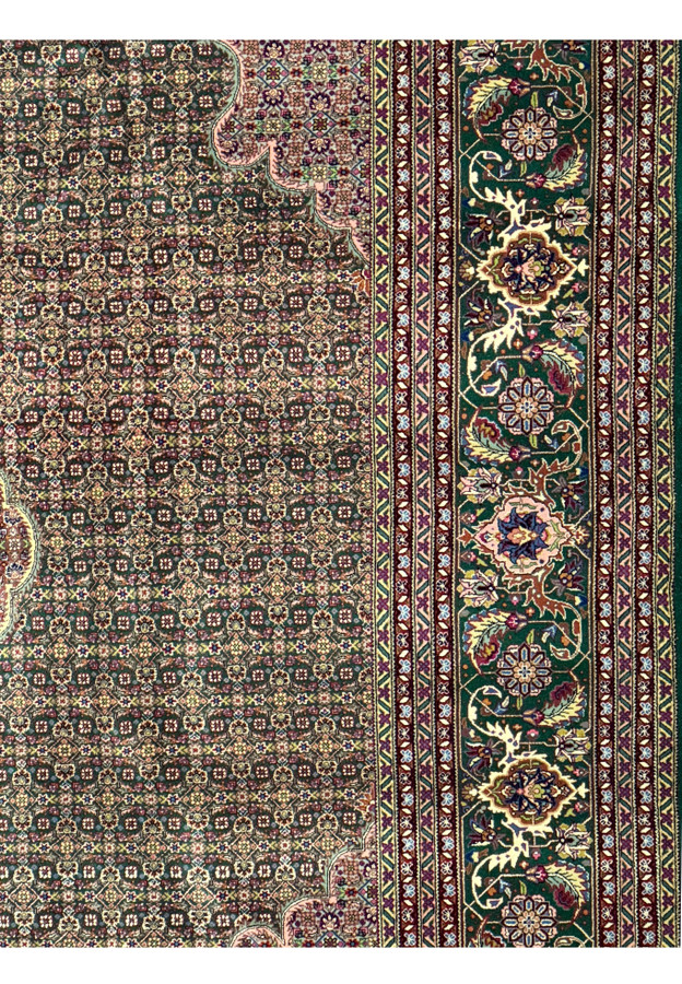 Detailed floral patterns and fish motifs on a Persian Tabriz 50 Raj rug.
