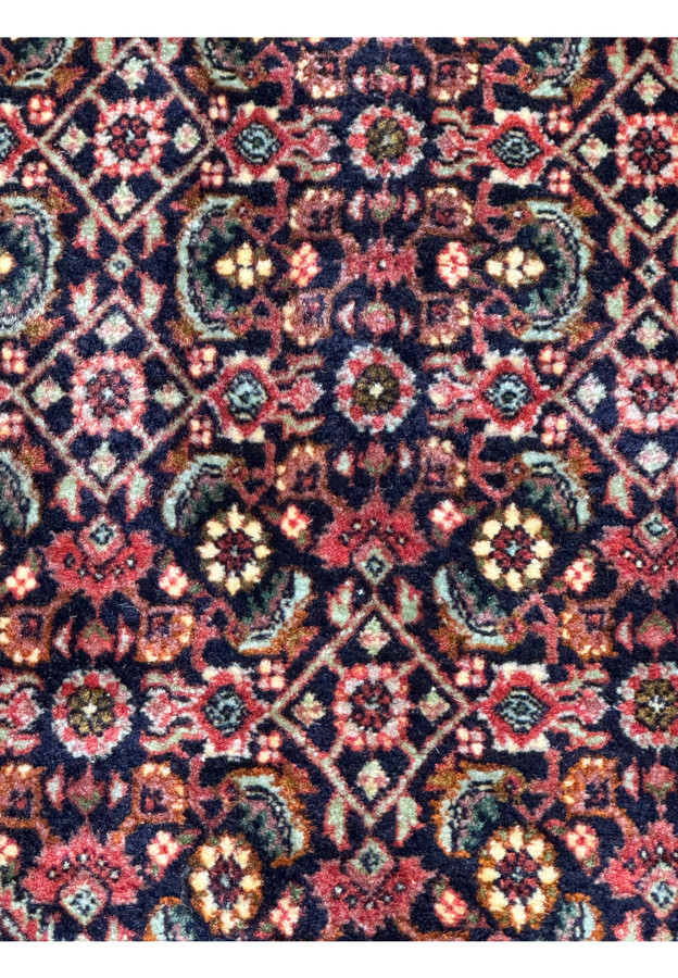 Perspective view of the Persian Bijar rug showing the rich texture and the complex interplay of colors in the traditional patterns