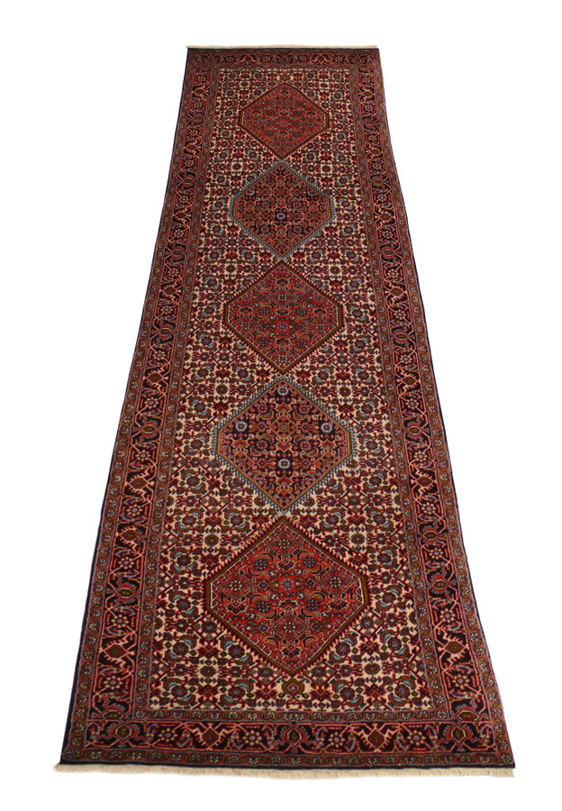 Long, 2'9 x 10'2 Persian Bijar Runner Rug laid out, showcasing detailed borders and diamond-shaped medallions in vibrant hues.