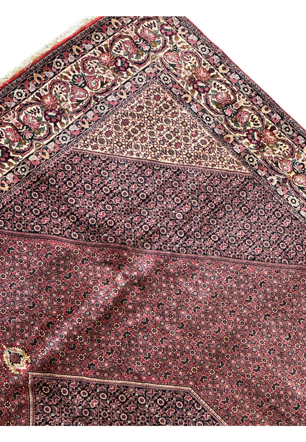 This image highlights both the intricacies of the border design and the durable leather backing on the backside of the Persian Bidjar rug, which ensures it remains smooth and unwrinkled.