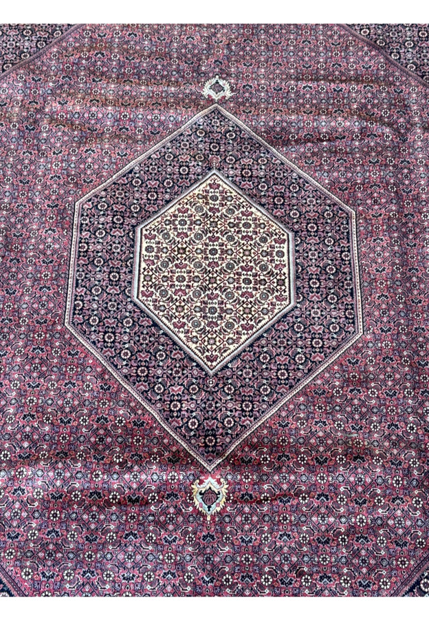 Overhead perspective of a 11x11 Persian Bijar square rug, emphasizing the symmetrical layout and rich color palette, from deep burgundy to soft beige and blue accents