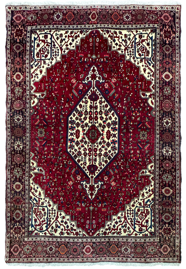 Overhead view of a 4'7" x 6'7" Persian Qum Kork rug featuring a rich red field with a central floral medallion and intricate cream border