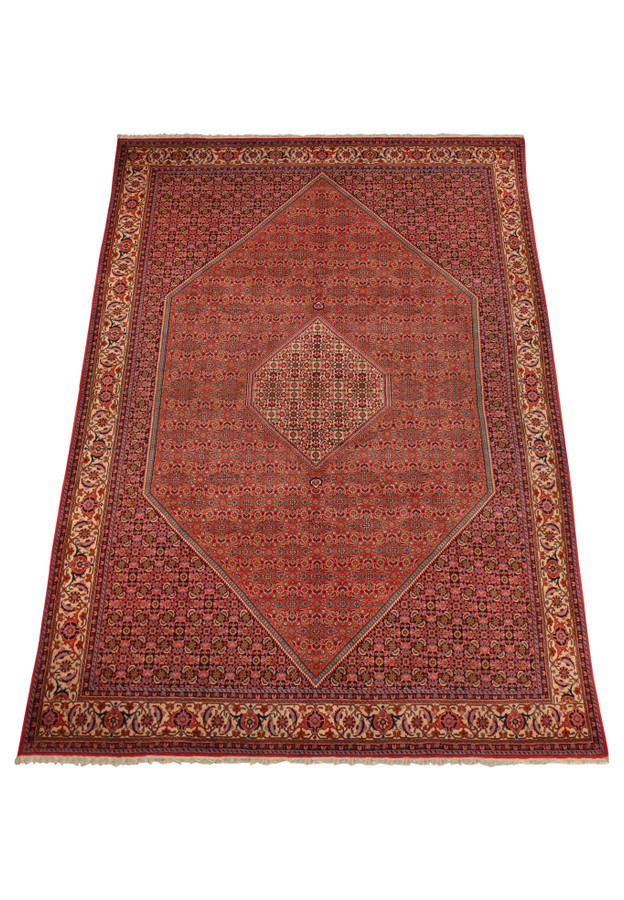 A full view of the Bijar Persian rug spread out, showcasing the symmetrical beauty of its design, from the central medallion to the elaborate corner brackets and the ornate outer border, with a soft sheen highlighting its high-quality fibers.