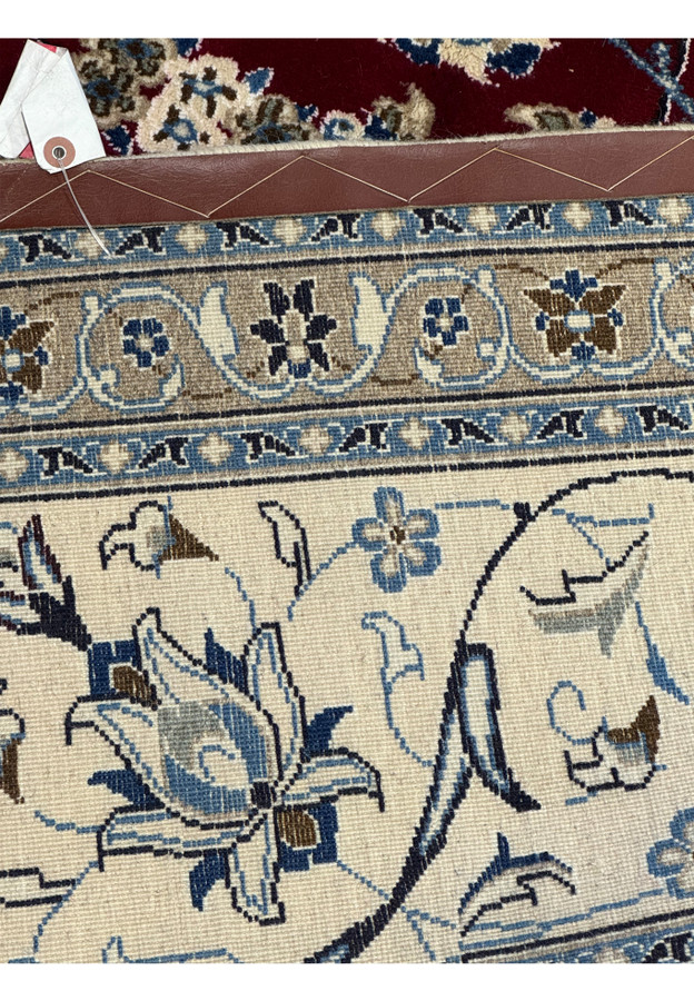 Close-up view of the side border of the Persian Nain 9La rug, detailing the precise floral patterns in navy and cream on a light blue background, highlighting the silk accents