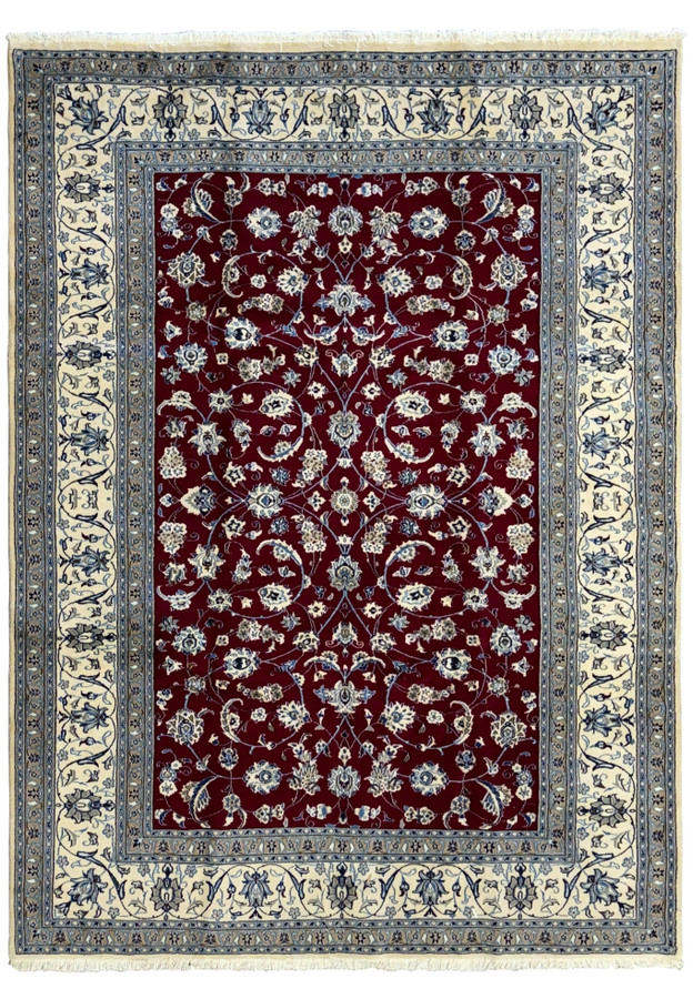 Overview of an 8x11 Persian Nain 9La rug displayed flat, featuring a deep red central field with intricate floral and vine motifs in cream, navy, and light blue, framed by multiple detailed borders.