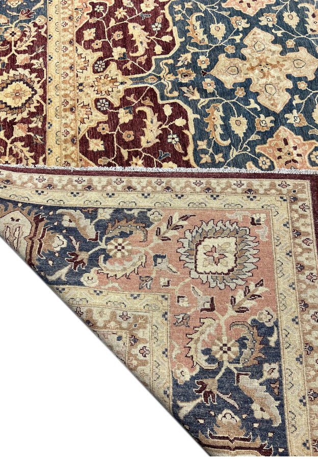 Close-up of the Agra rug's detailed pattern, featuring a combination of traditional floral and geometric designs. The rug's rich maroon, navy, and beige colors are clearly visible, emphasizing its luxurious appeal.