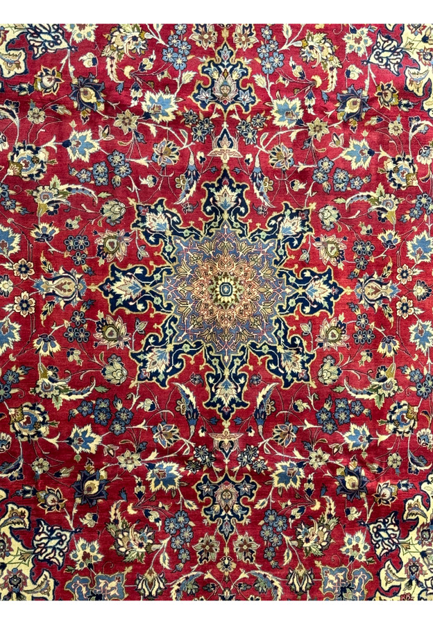 Close-up of the central medallion on a Persian Isfahan rug, featuring blue and gold intricate patterns