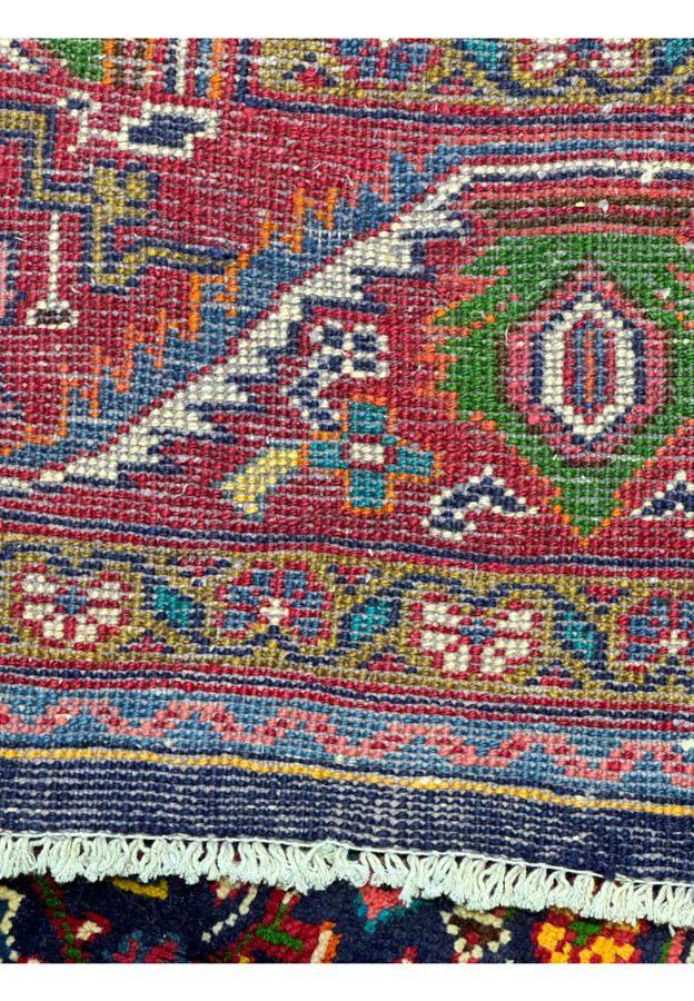 Close-up view of the back of a Persian Mahal Rug, revealing the detailed weave and the high-quality craftsmanship. The reverse side showcases the meticulous hand-knotting that creates the intricate floral and geometric patterns on the front. The vibrant colors are visible even from the back, indicating the rich dyes used in the wool. This image highlights the durability and the superior construction of the rug, making it a valuable addition to any home decor.
