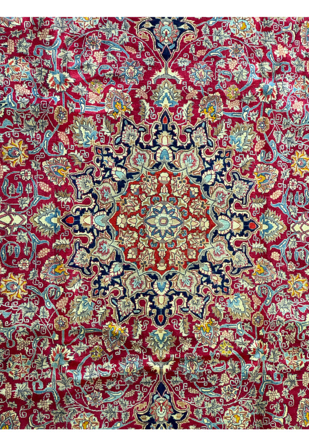 Close-up of the Persian Mahal rug's intricate weaving, showcasing the precision of its floral motifs against a vibrant red field. This rug blends traditional artistry with contemporary appeal.