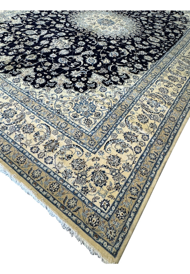 Side view of the 13x19 Nain Persian rug rolled up, emphasizing the high-quality wool and silk materials, detailed patterns, and rich colors, perfect for adding a touch of luxury to mansions and palaces