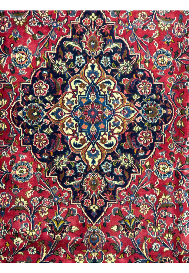 Close-up of the central medallion on a Persian Kashan Rug, showcasing intricate designs and color combinations.