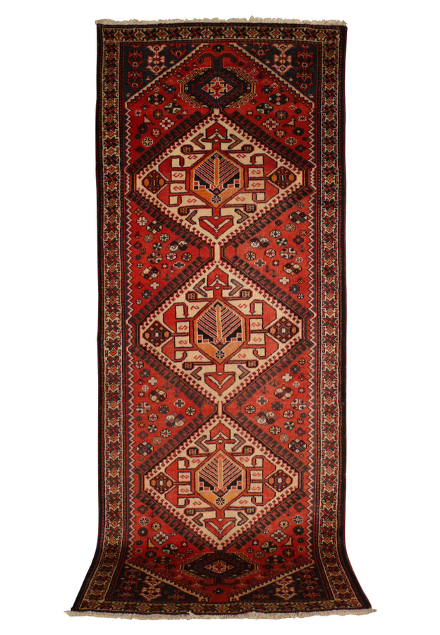 3'8" x 10' Persian Bakhtiar runner rug, showcasing its intricate geometric patterns and bold central medallions in rich red, orange, ivory, black, and green colors. The high-quality wool and fine craftsmanship are evident, making it a perfect addition to any hallway or narrow space.