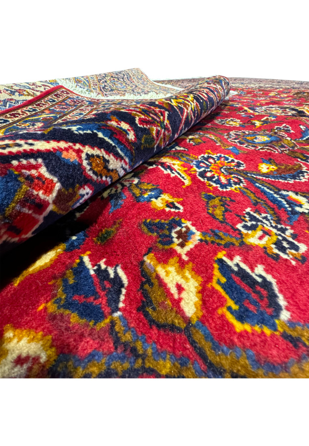 Rolled Persian Kashan Rug displaying the dense weave and vibrant patterns.