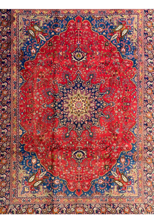 Close-up of the central medallion on the Persian Mashad rug, featuring floral and vine patterns.