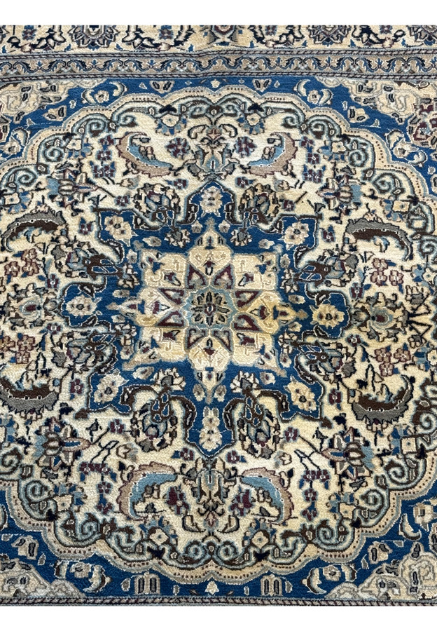 Close-up of the central medallion on the Persian Nain Square Rug, highlighting the detailed floral motifs.