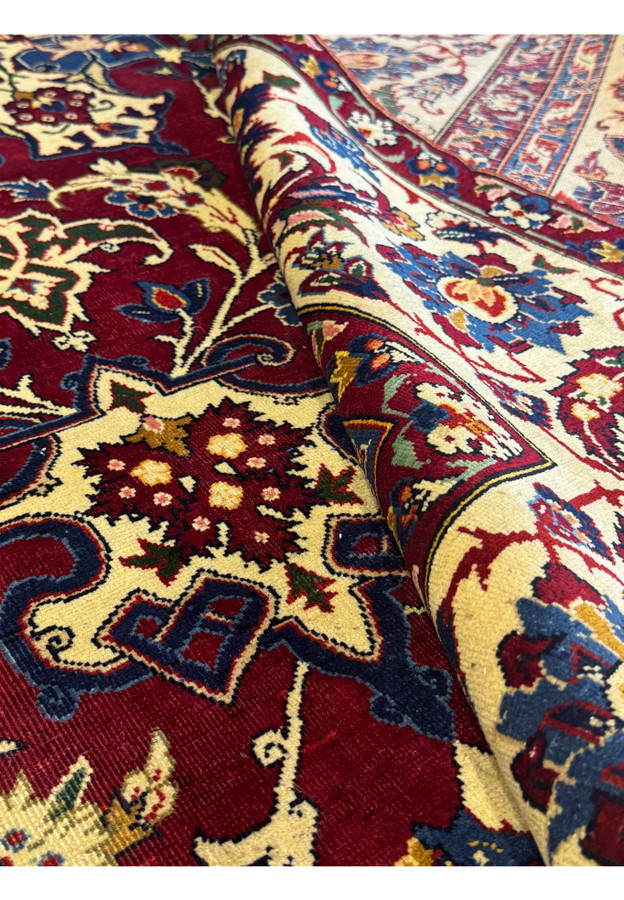 8 x 11'4 Persian Bakhtiar Rug partially rolled, showing a zoomed-in view of the detailed patterns.