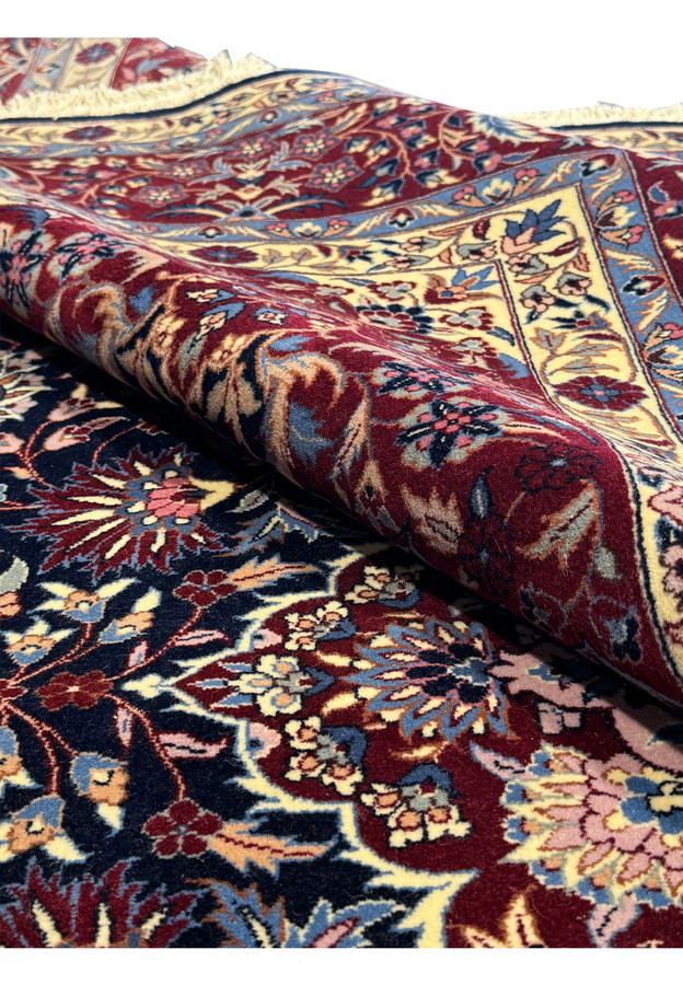 6'2 x 9'6 Persian Isfahan Rug partially rolled, showing a zoomed-in view of the detailed patterns