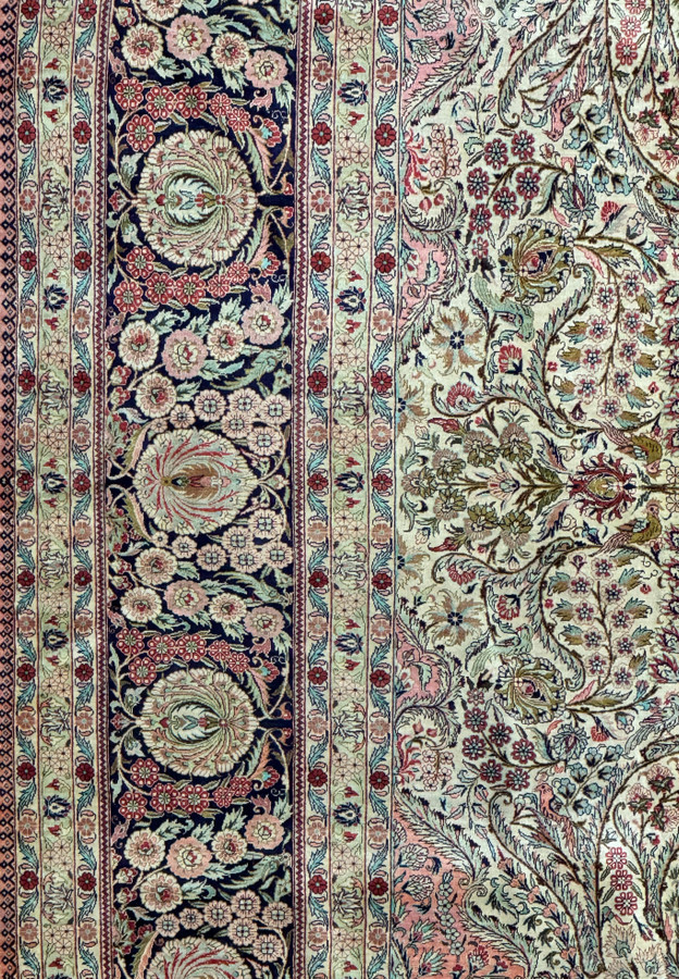 Corner detail of a Persian Tabriz 100% silk rug showcasing floral border design