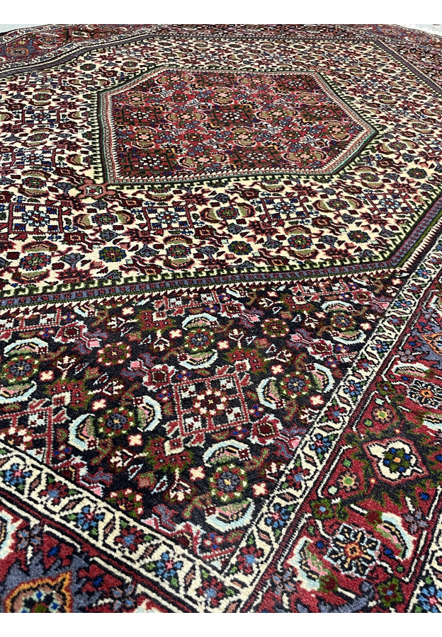 Side angle of a 3'8" x 5'9" Persian Bijar rug, showing the full array of colors including red, navy blue, ivory, green, and hints of yellow and pink.