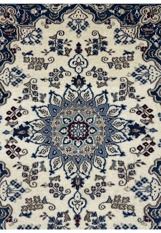 Medallion of a 2'10 x 4'8 Persian Nain Rug with light blue and beige accents.