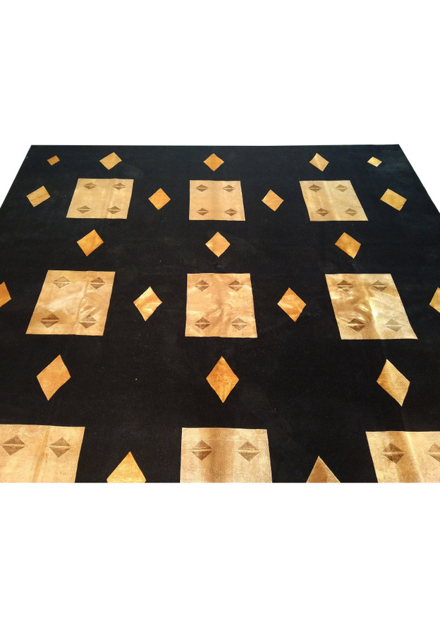 Upper part of 8'9 x 11'10 contemporary rug with black background and gold motifs.