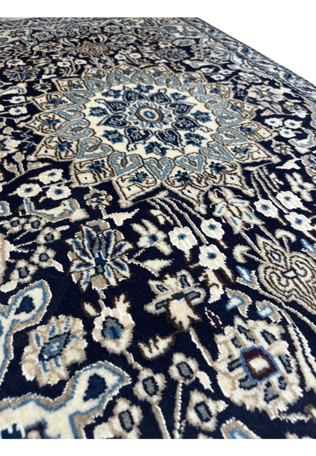 Side view of a 3x5 Nain Persian rug displaying its thickness and weave texture.