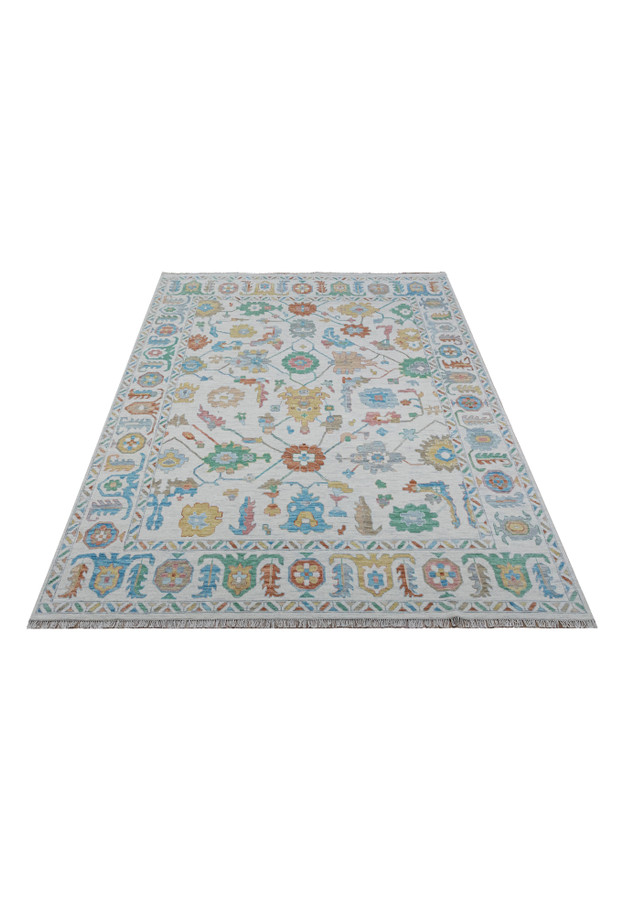 Oushak rug displayed fully, showcasing intricate pastel patterns.