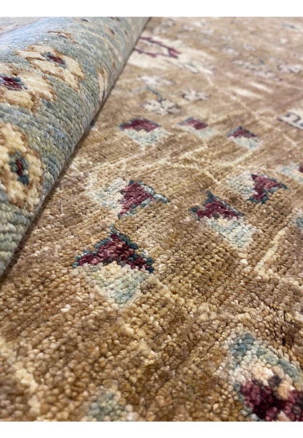Rolled up 12x16 Oriental Ziglar rug highlighting texture.
