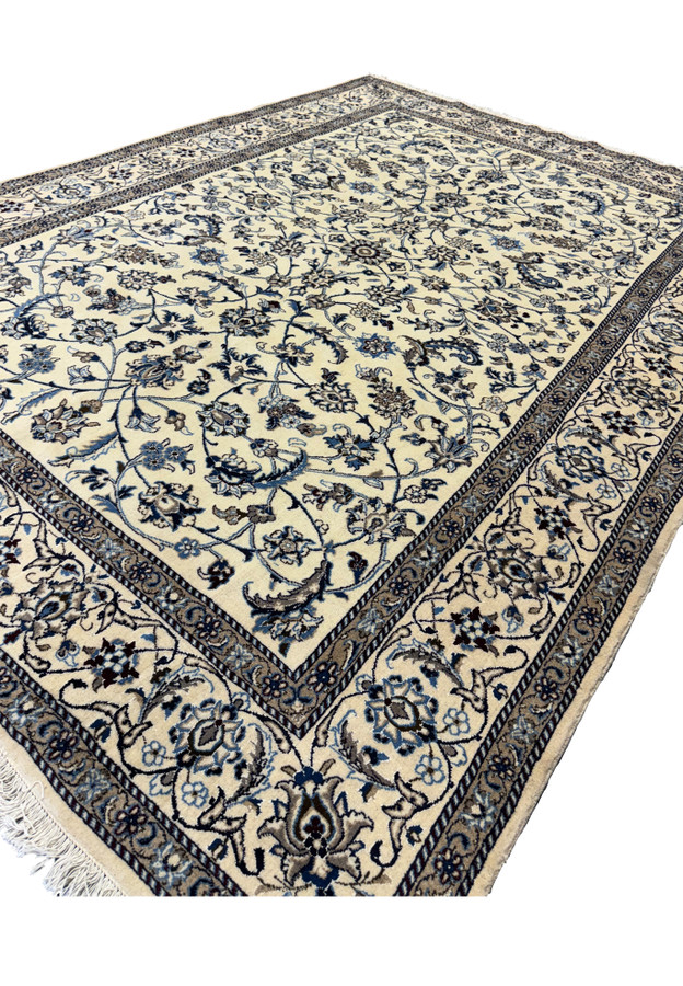 Angled view of the 8'2 x 11'6 Persian Nain rug with detailed floral and vine motifs.