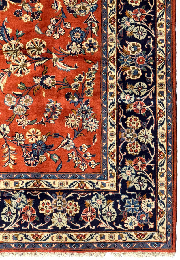 Border detail of 6'6 x 10'2 Persian Sarough Rug featuring navy blue with floral patterns and a contrasting burnt orange field.