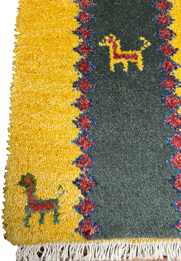 Lower part of the Persian Gabbeh Poshti rug with stylized horse figures and colorful accents.