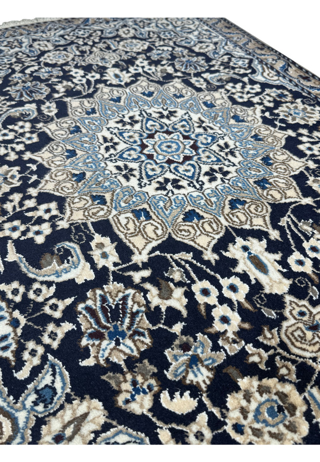 Angled view of 3'1 x 5 Persian Nain Rug displaying floral and geometric designs.