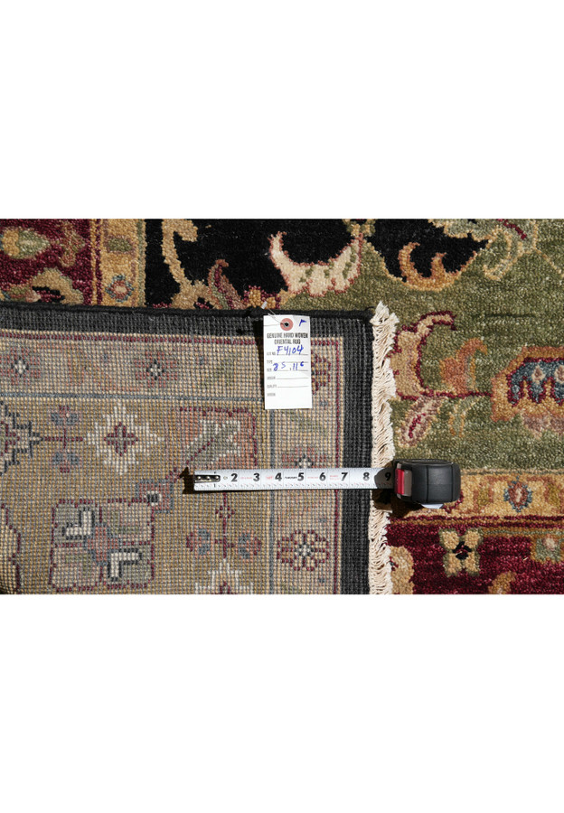 Backside of 8.5 x 11.6 Oriental Oushak rug showing fine hand-knotting, fringe, and item tag with black, burgundy, and green field detail.