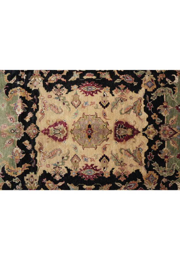 Center field view of the Oriental rug with symmetrical antique medallion and strong black contrast on a tan background.