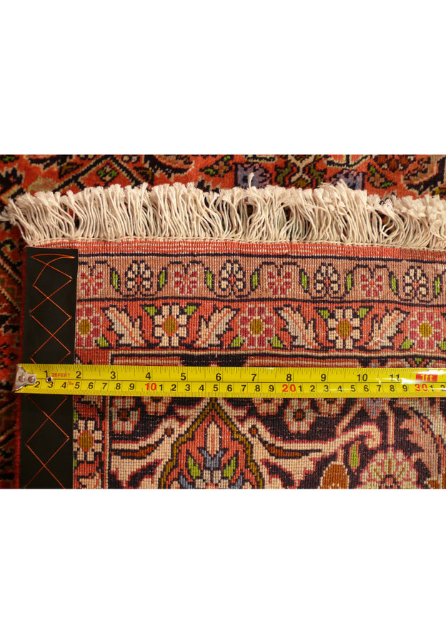 Measurement photo of knot density indicating fine weaving typical of high-quality Persian rugs.