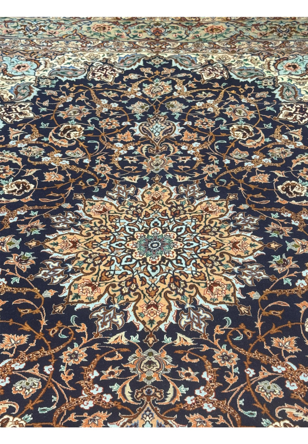 Close-up of central medallion on 5x8 Persian Isfahan rug with symmetrical floral starburst in beige and turquoise silk