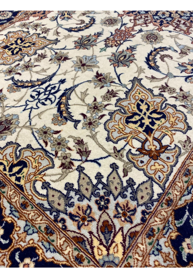 Close-up of central navy medallion with floral starburst design in blue, rust, and gold on Persian Isfahan runner.