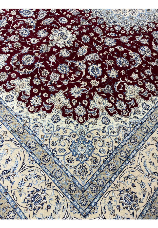 Side border of Persian Nain 9 LAA rug with ivory, blue, and beige floral patterns