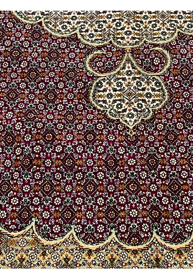 Pattern close-up of Tabriz 50 Raj Persian rug showing fine burgundy floral lattice with ivory and blue highlights on high-knot wool weave.