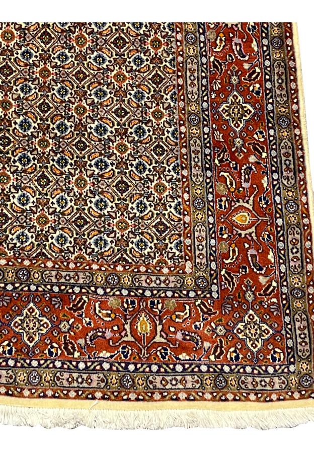 Detailed border with rust red field, floral palmettes, and vine patterns.