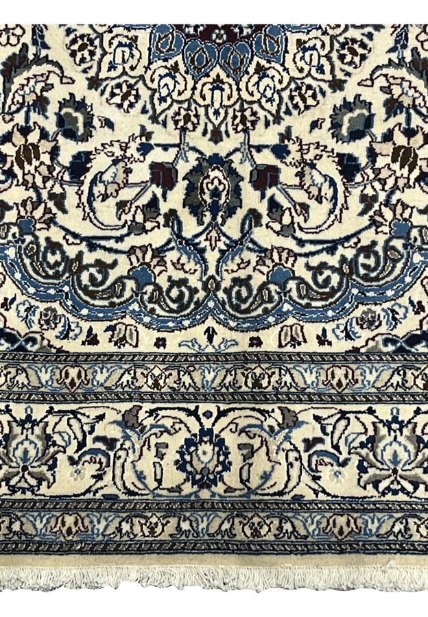 Lower edge of Square Nain Rug with ivory background, navy blue floral border, and silk highlights
