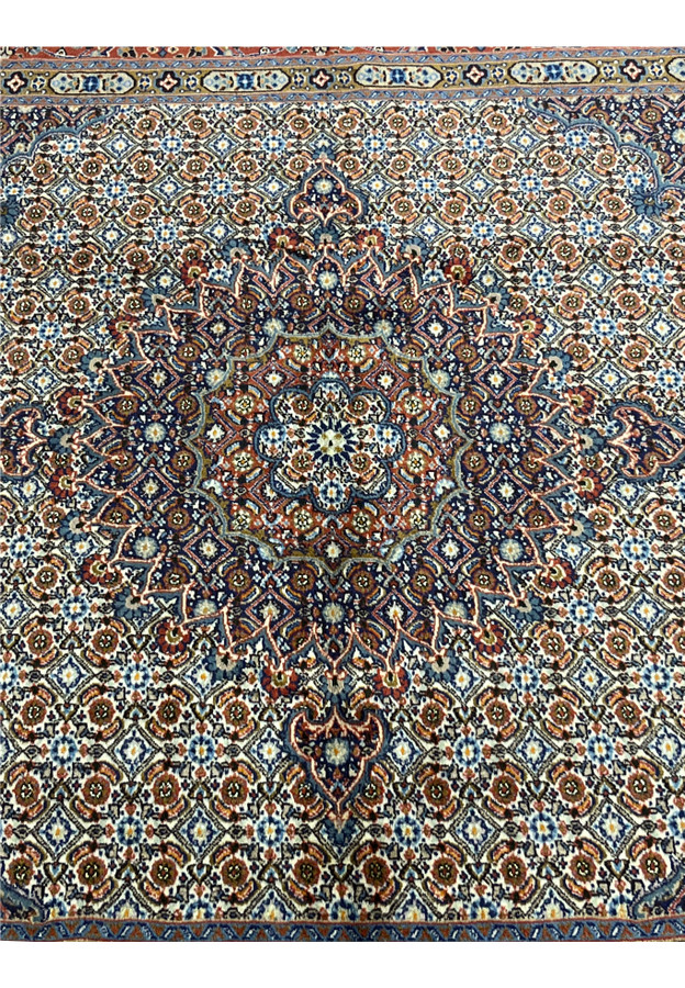 Close-up of the central field revealing the dense floral Herati motifs with shades of ivory, rust, navy, and olive, highlighting the high knot density and expert Persian weaving.
