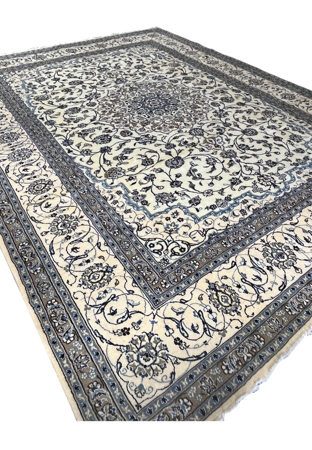 Angled view of 10' x 13'2 Persian Nain 9LA Rug revealing depth of pile and luminosity of silk on ivory and blue motifs.