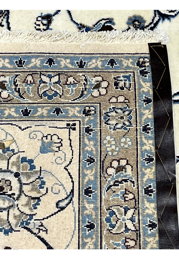 Backside of 10x13 Persian Nain 9LA Rug showing precise hand-knotted construction with cotton foundation and blue-taupe detailing.