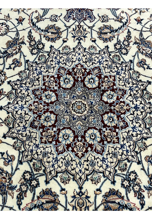 Closeup of Persian Nain 4 LA Habibian rug medallion showing precision knotting, silk highlights, and harmonious blend of blue, ivory, and burgundy.
