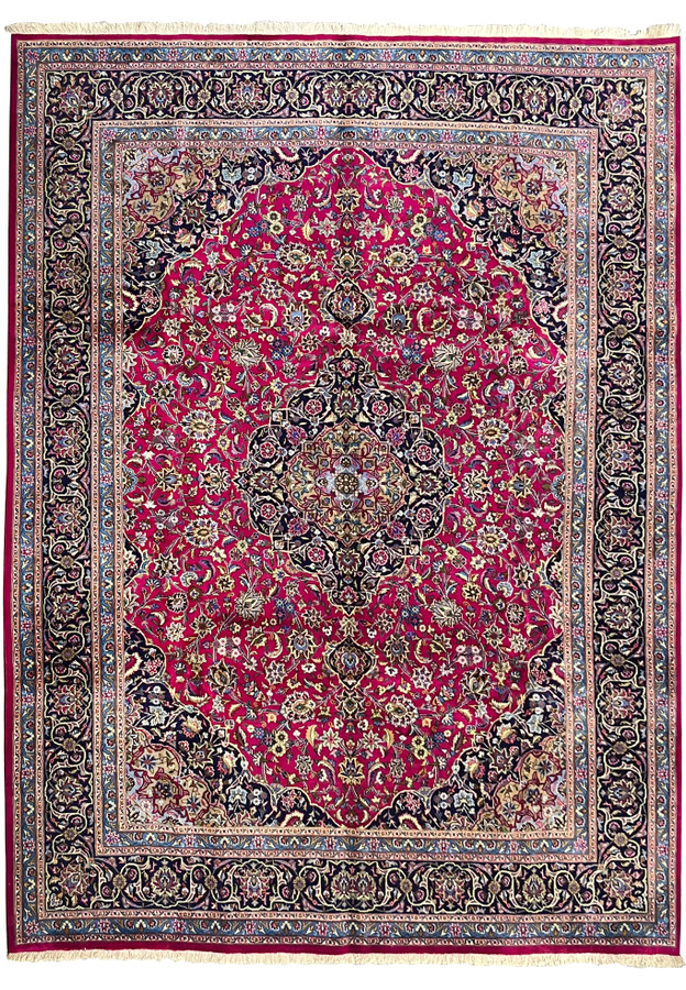 Full laid-down view of 9'9 x 12'8 semi-antique Persian Mashad red wool rug with navy border and central medallion.