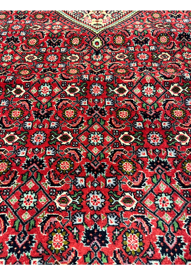 closeup of 10x13 Bijar Persian rug medallion showing intricate red, ivory, and green motifs